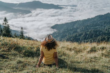 Woman traveler hipster looking forward at amazing mountains and valley view.