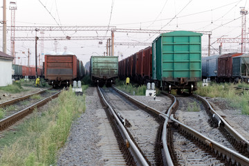 Fototapeta na wymiar Сargo wagons parked at the railway freight station at a sunny summer evening