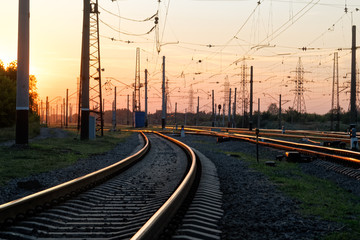 Fototapeta na wymiar Railway pointwork, railway tracks on the station at summer sunset. Transportation