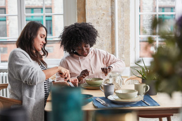 Zwei Frauen essen Müsli zum Frühstück in Küche