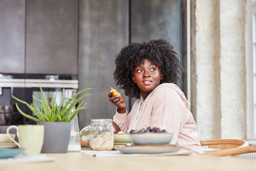 Afrikanische junge Frau beim Frühstück essen