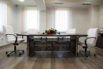Empty corporate conference room with white armchairs