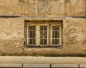 Old wooden window with metal frame on the old ruined wall
