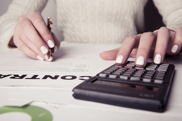  hand with pen, calculator, sheet and graph