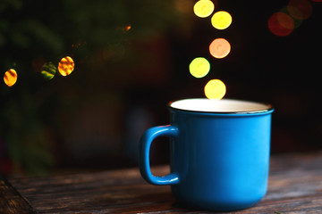 a cup on the wooden background . Christmas bokeh