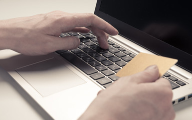 Businessman hand holding credit card and use laptop