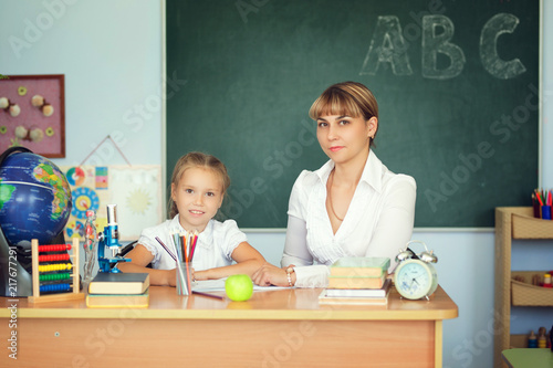 Teacher And Her Students In Classroom Teacher Helping Schoolgirl With Her Homework In Classroom At Teacher And Her Students In Classroom Teacher Helping Schoolgirl With Her Homework In Classroom At