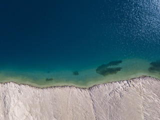 Vista aerea di scogli sul mare. Panoramica del fondo marino visto dall’alto, acqua trasparente. Vista aerea della spiaggia di Rucica sull’isola di Pag, Metajna, Croazia