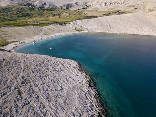 Vista aerea della spiaggia di Rucica sull’isola di Pag, Metajna, Croazia. Fondale marino trasparente natura selvaggia e desertica, vacanze estive. Promontori e scogliere delle coste croate.