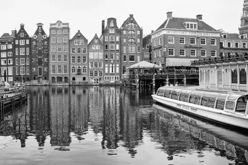 Fotobehang Palazzi cartteristici di Amsterdam riflessi nell' acqua di un canale, bianco e nero © makis7