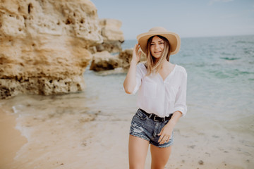 Happy woman at the beach enjoying her summer holidays. Young woman walking in the beach