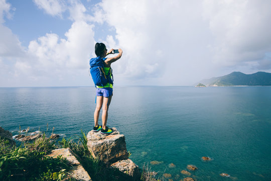 Woman Hiking In Seaside Taking A Selfie with mobile phone