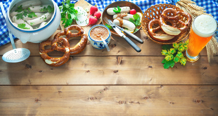 Bavarian sausages with pretzels, sweet mustard and beer on rustic wooden table