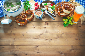 Bavarian sausages with pretzels, sweet mustard and beer on rustic wooden table