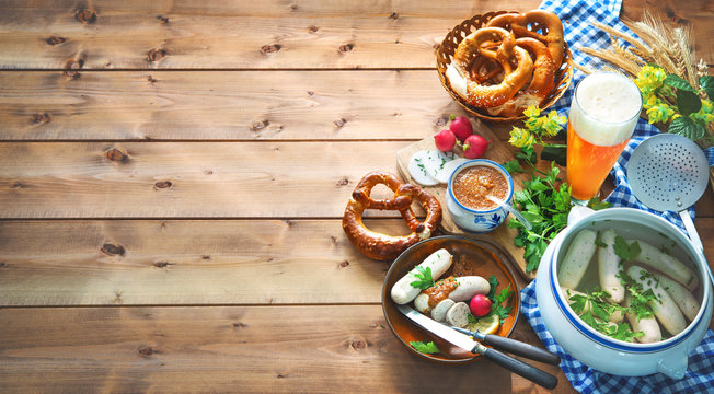 Bavarian sausages with pretzels, sweet mustard and beer on rustic wooden table