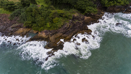 Aerial view of a rocky and green beach shore.