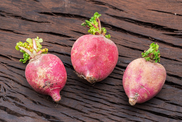Radish taproots on the wooden background.