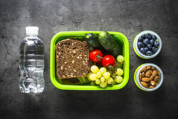Lunch box with sandwich, vegetables, banana, water, nuts and ber