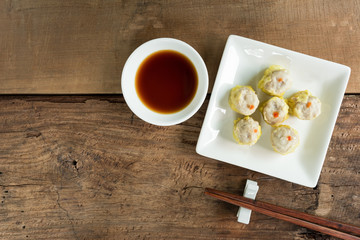 top view of pork shumai served with soy sauce on wooden table. popular chinese food appetizer