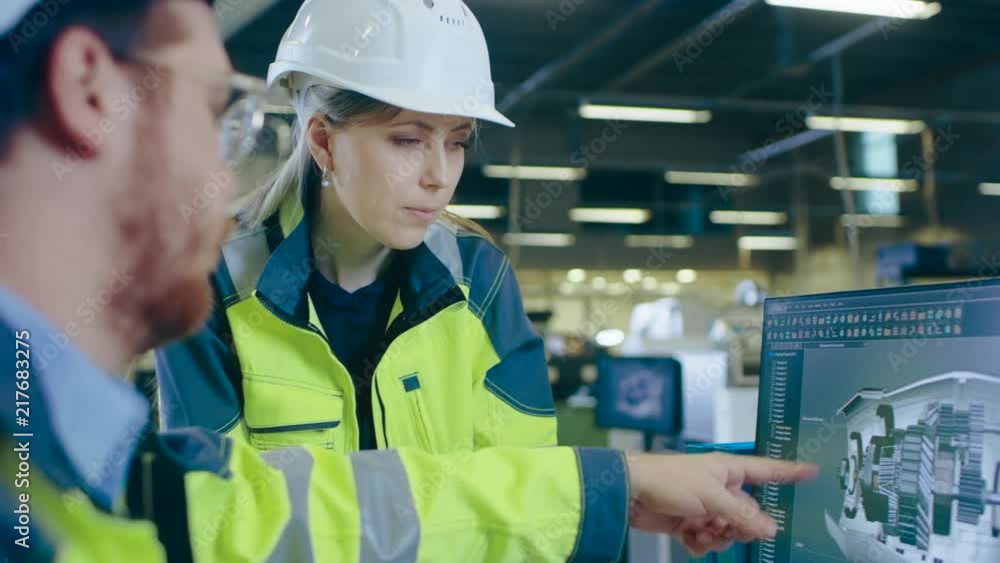 Aufkleber at the factory: male mechanical engineer and female chief engineer work together on the personal com