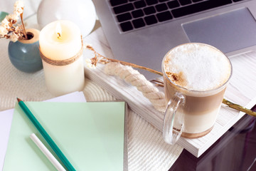work desk with laptop, coffee and candle