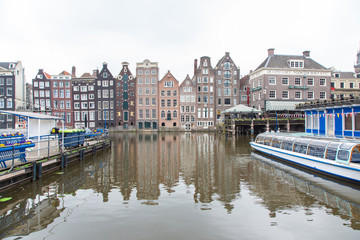 Fototapeta premium Charakterystyczne budynki Amsterdamu, które odbijają się w wodzie kanału