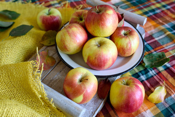 Red yellow apples and autumn leaves on the table