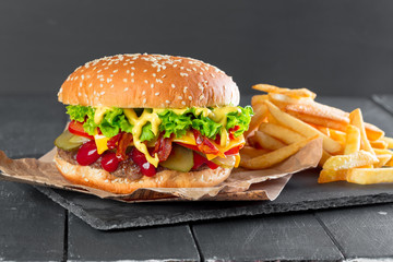 Hamburger with fries on a slate plate