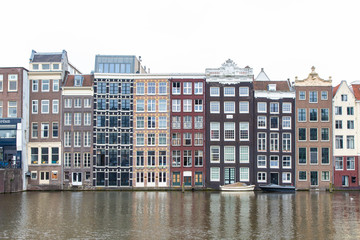 Fototapeta premium Charakterystyczne budynki Amsterdamu, które odbijają się w wodzie kanału