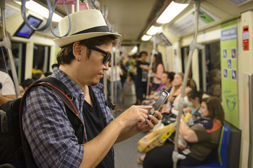 Japanese man tourist looking mobile phone in the subway train