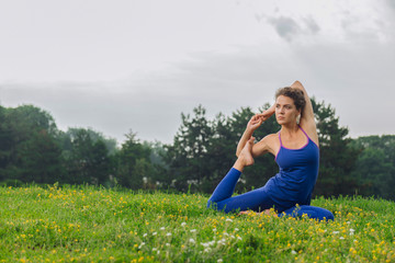 Improving flexibility. Beaming curly woman feeling free and calm while improving her flexibility with stretching