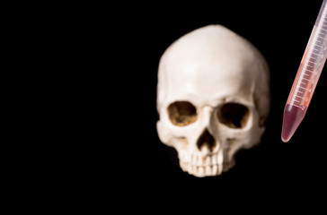 blood sample and skull on black background