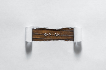 reboot - an inscription in the torn white paper. The concept of rebooting, restart.