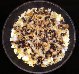 Frying the filling for a mushroom pie