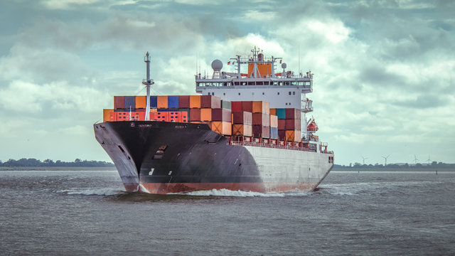 Containerschiff in Fahrt auf der Elbe bei Hamburg
