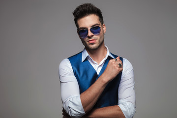 Obraz premium portrait of attractive stylish man wearing blue sunglasses and gilet