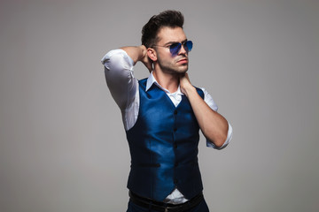 seuctive man with sunglasses poses while looking to side