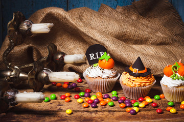 Halloween cupcakes with colored decorations, soft focus background