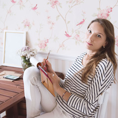 Businesswoman writing notes on notepad. Female executive sitting at her desk taking notes.