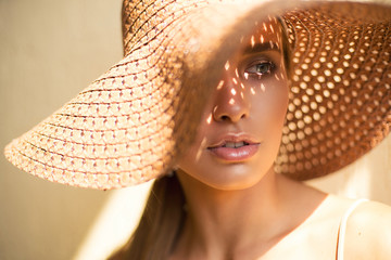Close-up Fashion woman portrait of young pretty trendy girl in hat posing at the city, summer street fashion.