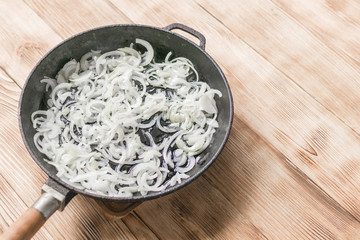 Fried onions in a frying pan. Roasting the chopped onion in oil.