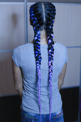 thick braids with interlacing of artificial material, colored synthetic hair, build-up, the girl is braided in a hairdress, the result of the work of the master