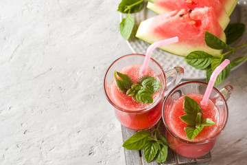 Fresh watermelon smoothie with ice and mint leaves in glasses. opy space