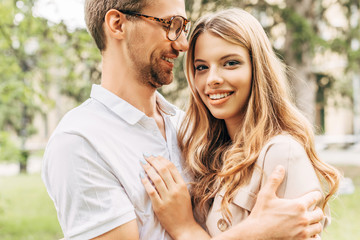 Fototapeta premium bottom view of happy young couple embracing at park