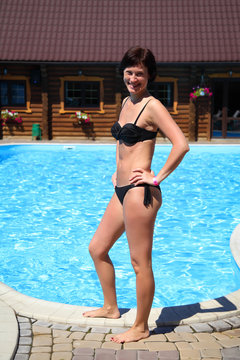 Beautiful mature woman posing for the camera against a turquoise water background. Woman in the pool. Beautiful sexy woman in pool during summer.