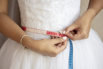 Bride measuring her waist