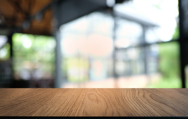 Empty dark wooden table in front of abstract blurred bokeh background of restaurant . can be used for display or montage your products.Mock up for space.