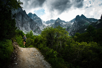 Trail Runner in Mountains, dark sky in background