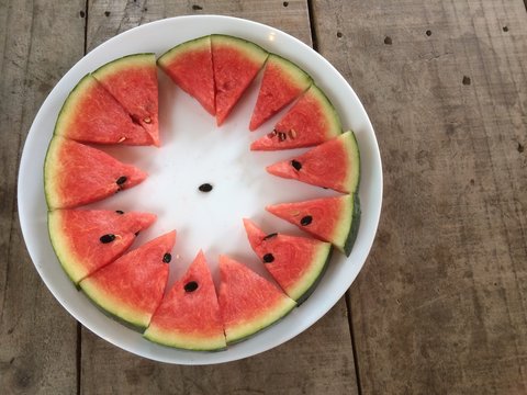 Sliced ripe watermelon place a sort of white plate around.