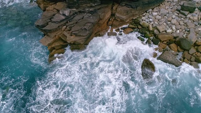 Aerial slow-mo of waves hitting rocky Atlantic coast at Cabo Carvoeiro, Portugal